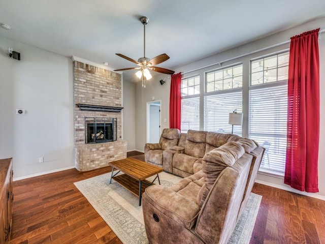 living area featuring a healthy amount of sunlight, a fireplace, baseboards, and dark wood finished floors