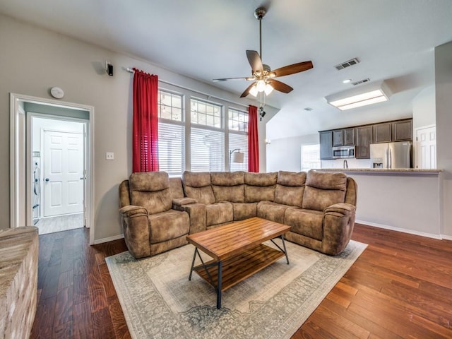 living room with plenty of natural light, visible vents, and dark wood finished floors