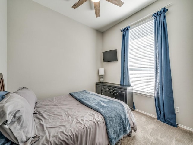 bedroom with light colored carpet, ceiling fan, and baseboards