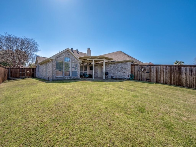 back of property with a fenced backyard, a chimney, a lawn, and brick siding