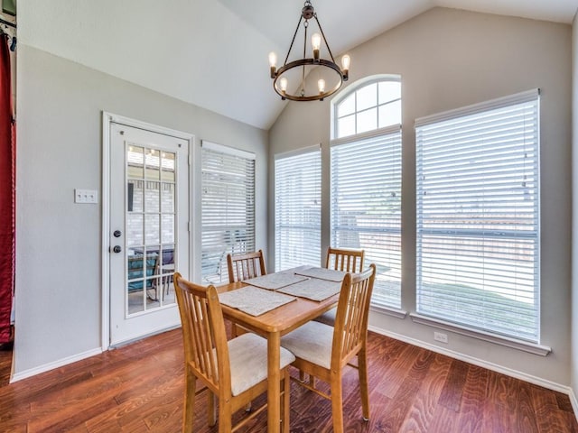 dining room featuring dark wood-type flooring, vaulted ceiling, baseboards, and an inviting chandelier