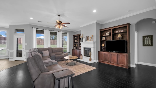 living area featuring dark wood-style floors, plenty of natural light, and a glass covered fireplace