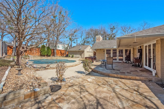 view of swimming pool with ceiling fan, a patio, a fenced backyard, french doors, and a fenced in pool