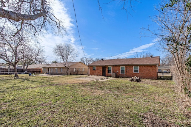 rear view of property with brick siding, a yard, a patio, and fence