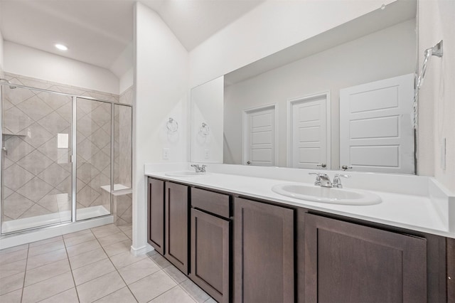 full bath with a sink, a shower stall, and double vanity