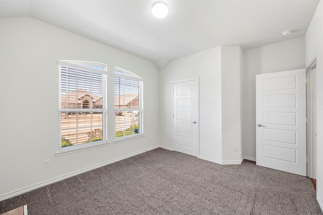 unfurnished bedroom with lofted ceiling, carpet flooring, and baseboards