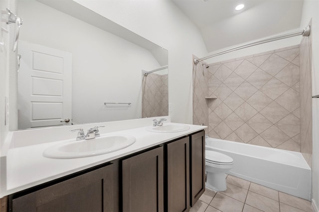 full bath featuring toilet, bathtub / shower combination, a sink, and tile patterned floors