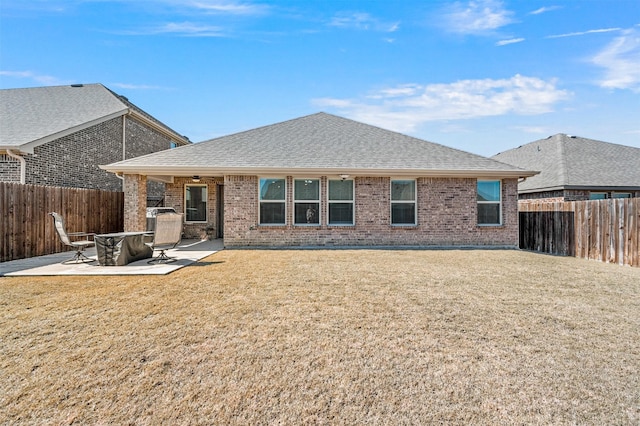 back of house with a yard, roof with shingles, a patio area, and a fenced backyard