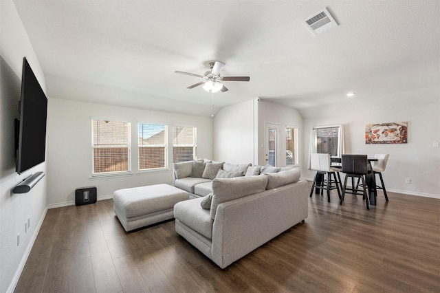 living area featuring dark wood-style floors, baseboards, visible vents, and ceiling fan