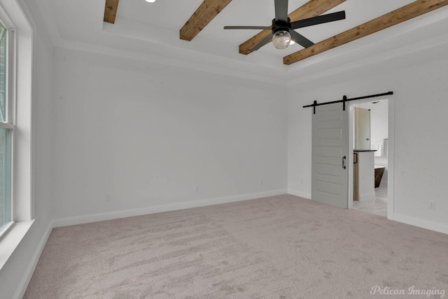 unfurnished room featuring carpet floors, ceiling fan, beamed ceiling, and a barn door
