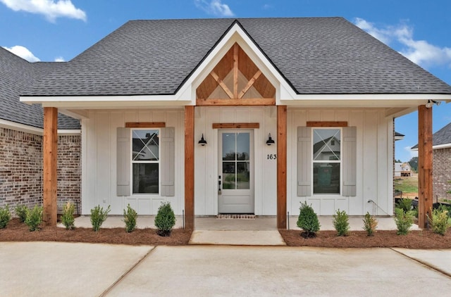 view of front of house with a shingled roof, a porch, and board and batten siding