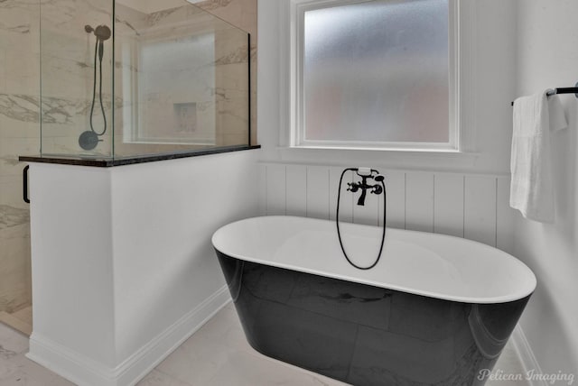 bathroom with a freestanding tub, baseboards, a stall shower, and marble finish floor