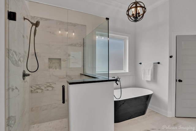bathroom with an inviting chandelier, a marble finish shower, marble finish floor, baseboards, and a freestanding tub