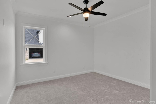 carpeted spare room with baseboards, ornamental molding, and ceiling fan
