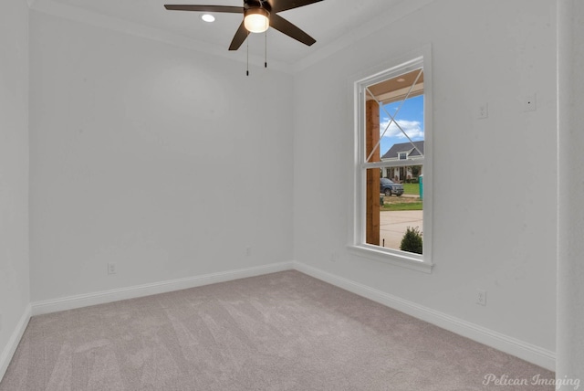 empty room with carpet floors, a ceiling fan, and baseboards