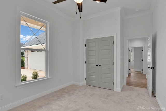 unfurnished bedroom featuring crown molding, baseboards, carpet, and a closet