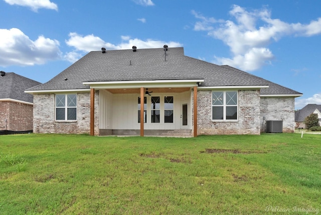 rear view of house featuring ceiling fan, a yard, brick siding, and cooling unit