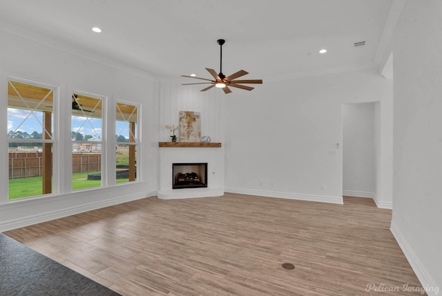 unfurnished living room with crown molding, a ceiling fan, and light wood finished floors