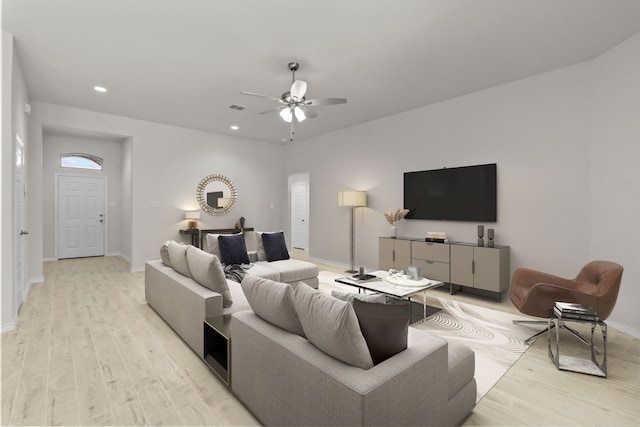 living area featuring baseboards, light wood finished floors, a ceiling fan, and recessed lighting