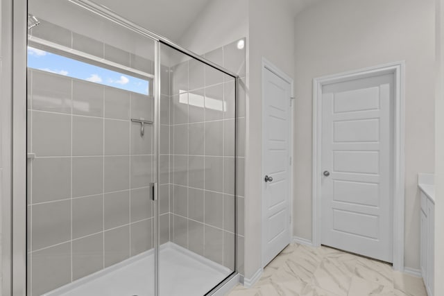 bathroom featuring marble finish floor and a shower stall