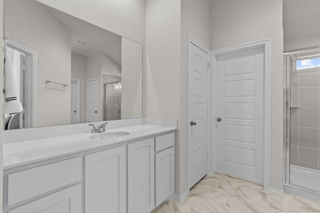 full bathroom featuring marble finish floor, vanity, and a stall shower