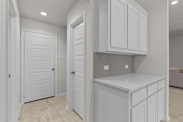 washroom featuring light wood-style flooring, baseboards, and recessed lighting