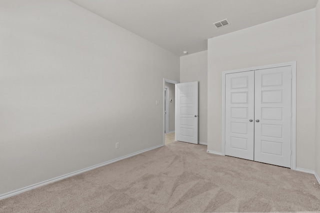 unfurnished bedroom featuring a closet, carpet flooring, visible vents, and baseboards