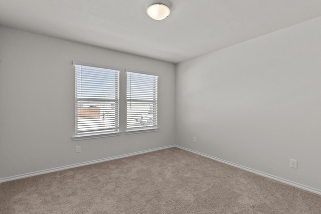 carpeted spare room with baseboards