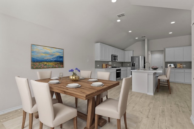 dining room featuring light wood-style flooring, recessed lighting, visible vents, baseboards, and vaulted ceiling