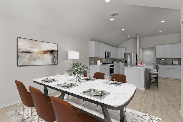 dining room with lofted ceiling, visible vents, light wood-style flooring, and recessed lighting