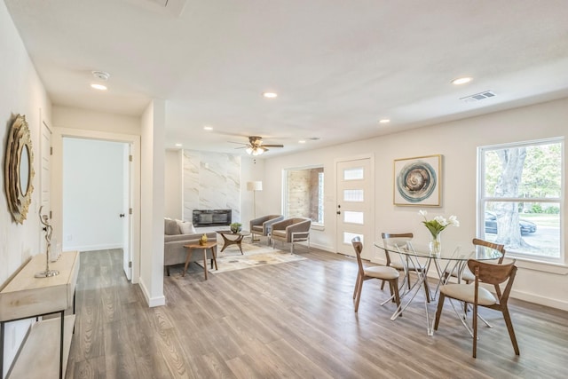 dining area featuring recessed lighting, a premium fireplace, wood finished floors, visible vents, and baseboards