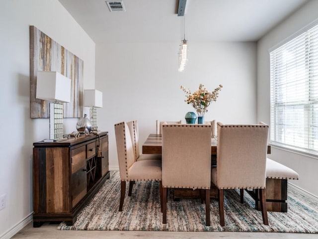 dining room featuring baseboards, visible vents, and wood finished floors