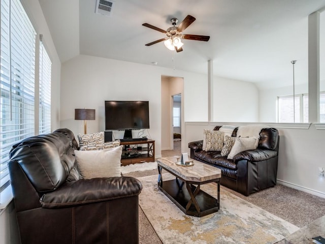 carpeted living room with lofted ceiling, baseboards, visible vents, and a ceiling fan