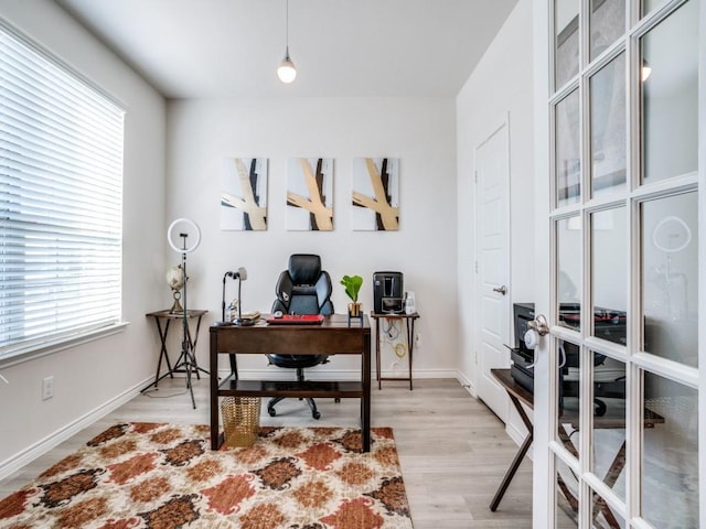 office area featuring light wood-type flooring, plenty of natural light, and baseboards