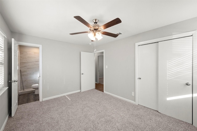 unfurnished bedroom featuring ensuite bathroom, ceiling fan, carpet flooring, baseboards, and a closet