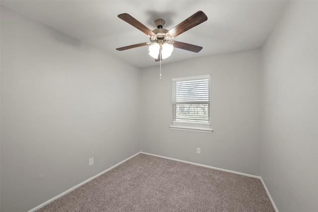 carpeted spare room with ceiling fan and baseboards