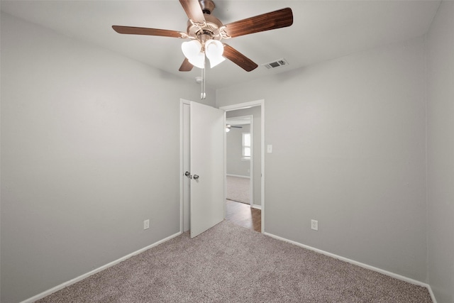 carpeted spare room with visible vents and baseboards