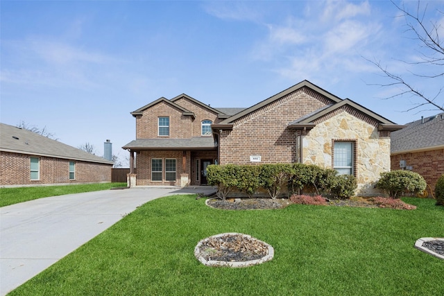 view of front of home featuring concrete driveway, brick siding, a front lawn, and stone siding