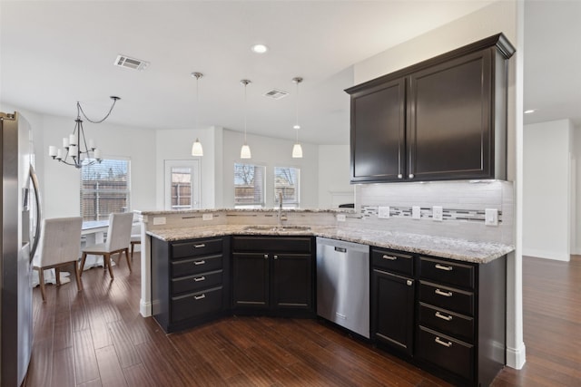 kitchen with visible vents, dark wood-type flooring, a peninsula, stainless steel appliances, and a sink