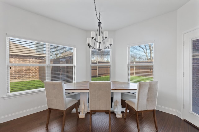 dining area with a notable chandelier, plenty of natural light, baseboards, and wood finished floors