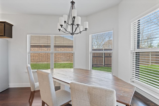 dining space featuring a chandelier, a wealth of natural light, and dark wood finished floors