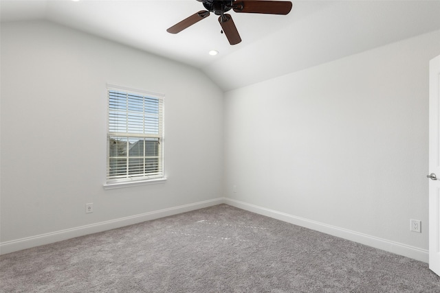 spare room with carpet floors, vaulted ceiling, and baseboards