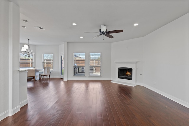 unfurnished living room with recessed lighting, dark wood-style flooring, visible vents, and a lit fireplace