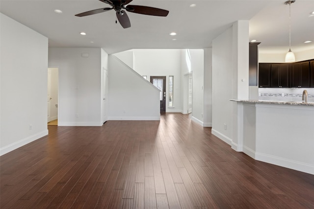 unfurnished living room featuring ceiling fan, baseboards, dark wood-type flooring, and recessed lighting