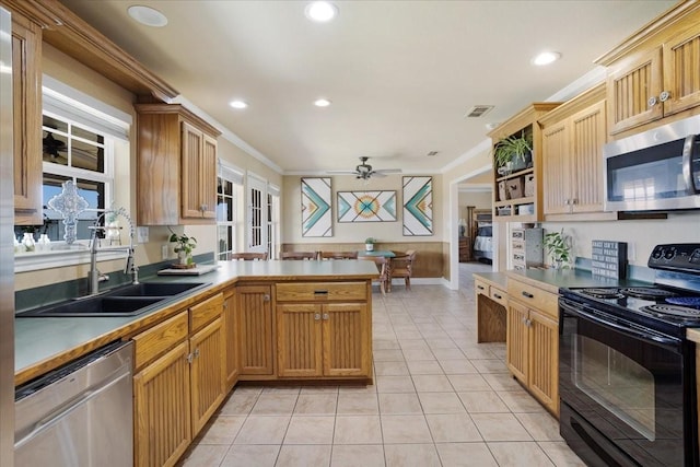 kitchen with a peninsula, appliances with stainless steel finishes, a sink, and crown molding