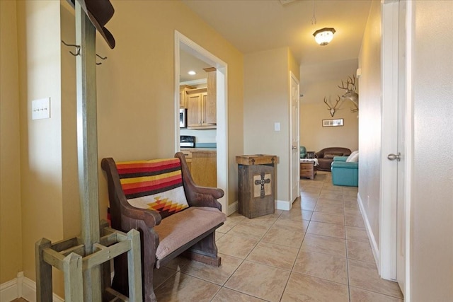 corridor with baseboards and light tile patterned floors