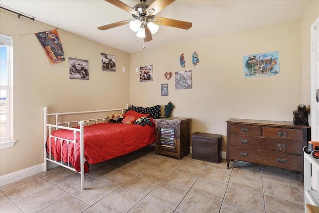 bedroom with light tile patterned floors, ceiling fan, and baseboards