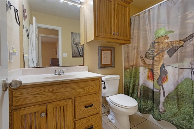 bathroom with toilet, tile patterned flooring, and vanity