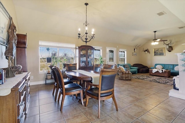 dining room with ceiling fan with notable chandelier, lofted ceiling, visible vents, and light tile patterned floors