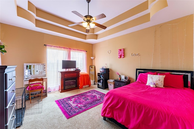 3630 Darnell Dr, Paris, TX 75462 - carpeted bedroom featuring a fireplace, a raised ceiling, and ceiling fan